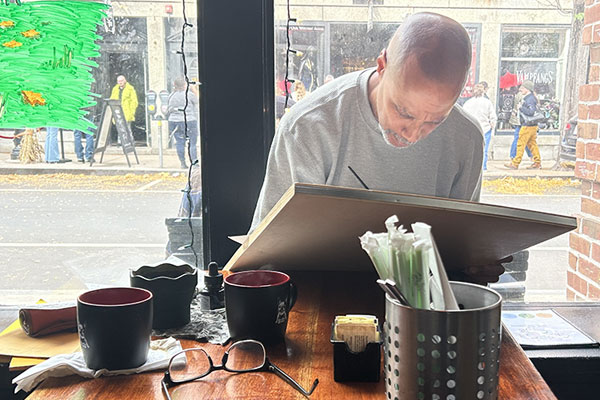 David Marshall drawing a comic book